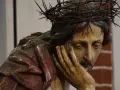Chrystus Frasobliwy, rzeźba z koroną cierniową i krwawymi ranami, zamyślony, opiera głowę na dłoni.