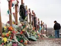 Pamięć o ofiarach masakry w Columbine High School. Krzyże ozdobione kwiatami i pamiątkami, obok stoi pogrążony w zadumie mężczyzna.