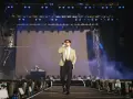 Taco Hemingway na scenie, w garniturze i z mikrofonem. Koncertowy klimat, światła i dym. To musi być koncert Taco Hemingway 2026!