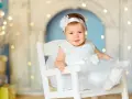 Uśmiechnięta Dorotka w białej sukience, jak aniołek. Jej imię, Dorota, znaczy "dar od Boga".