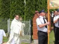 Ksiądz niesie monstrancję, a obok niego stoją policjanci. Może to być procesja, gdzie Krzysztof, jak jego imię znaczy "niosący Chrystusa", jest symbolem wiary.