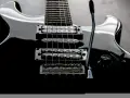 Czarna gitara elektryczna z sześcioma strunami, gotowa do rockowych riffów.