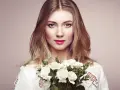 Piękna blondynka z bukietem białych róż. Jej spojrzenie sugeruje głębokie znaczenie imienia Aleksandra – obrończyni ludu.