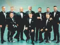 Dziesięciu mężczyzn w czarnych smokingach, tworzących 10 tenorów skład.