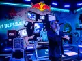 Jan rapowanie koncert w neonowym świetle. Na ścianie napisy "VHS RULES", logo Red Bulla i stare monitory.