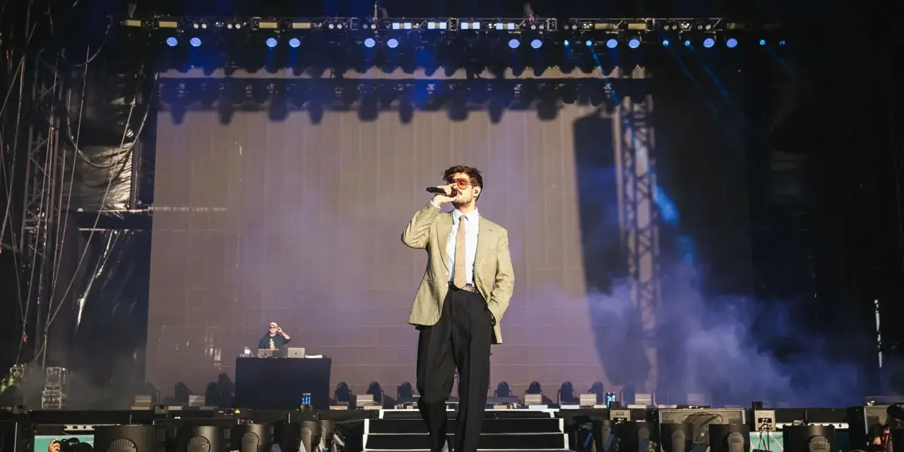 Taco Hemingway na scenie, w garniturze i z mikrofonem. Koncertowy klimat, światła i dym. To musi być koncert Taco Hemingway 2026!
