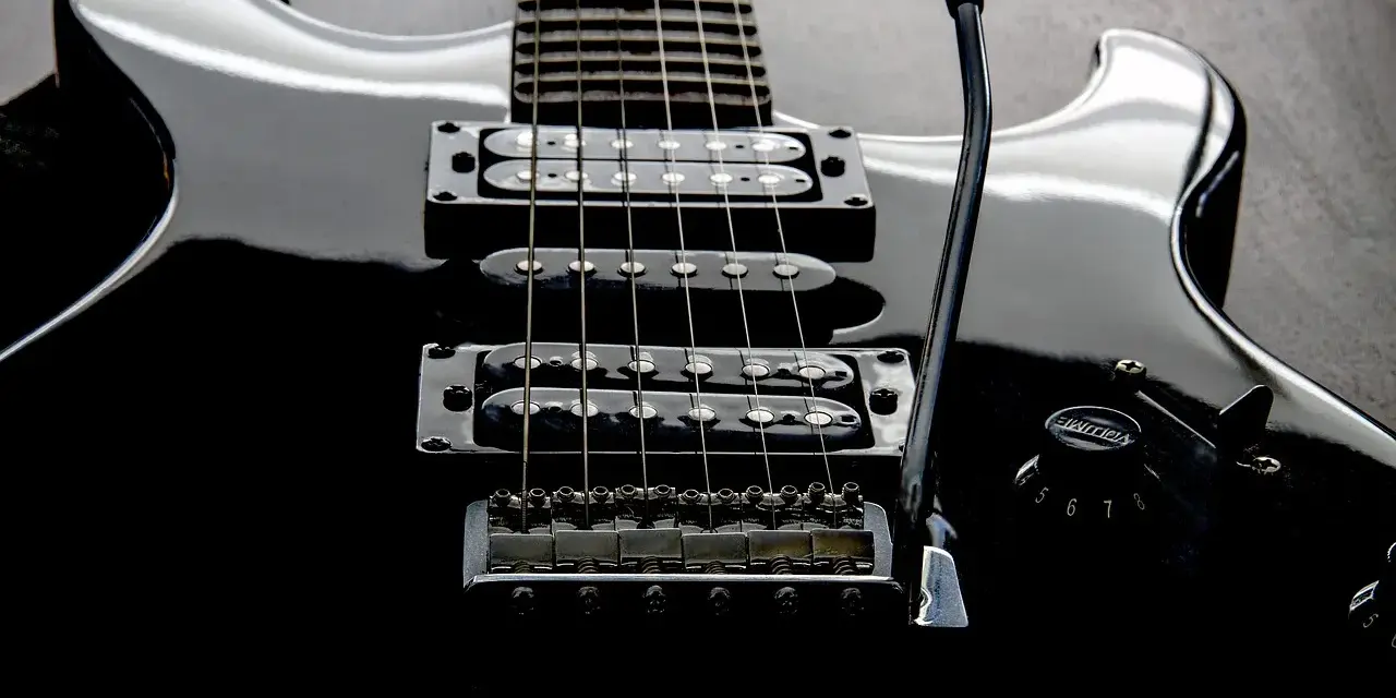 Czarna gitara elektryczna z sześcioma strunami, gotowa do rockowych riffów.