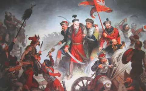 Bitwa pod Chocimiem 1621: Polacy z chorągwią zwyciężają. Dynamiczna scena walki, szable, broń palna, żołnierze w barwnych strojach.