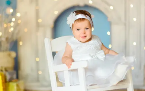 Uśmiechnięta Dorotka w białej sukience, jak aniołek. Jej imię, Dorota, znaczy "dar od Boga".