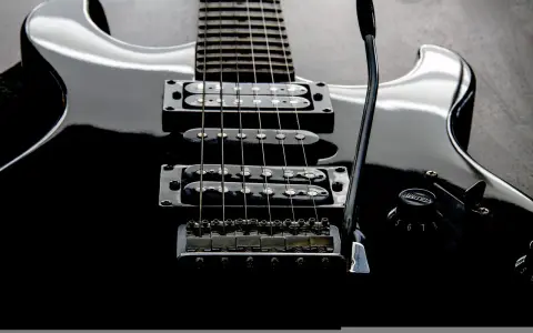 Czarna gitara elektryczna z sześcioma strunami, gotowa do rockowych riffów.