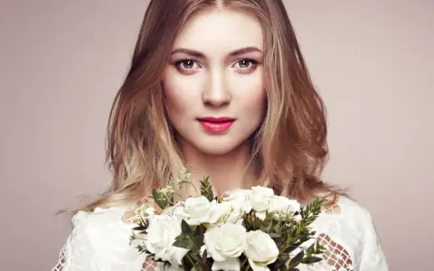 Piękna blondynka z bukietem białych róż. Jej spojrzenie sugeruje głębokie znaczenie imienia Aleksandra – obrończyni ludu.