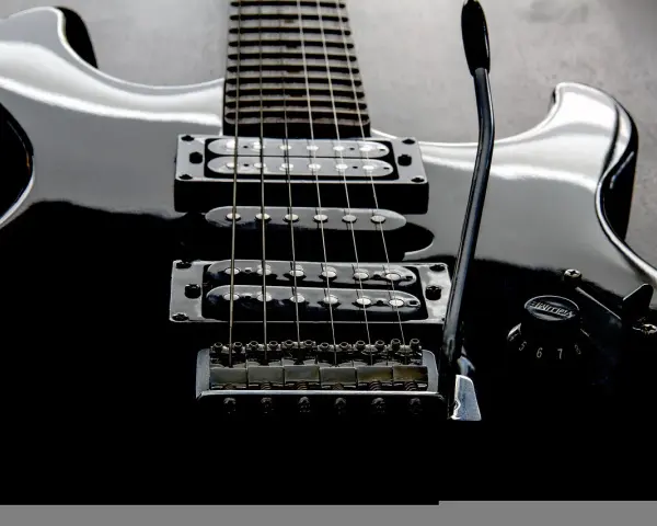Czarna gitara elektryczna z sześcioma strunami, gotowa do rockowych riffów.