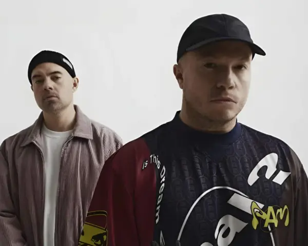Dwóch mężczyzn w czapkach, jeden w sztruksowej kurtce, drugi w bluzie z napisem "Is this dream". Czy to zapowiedź problem koncertów 2025?