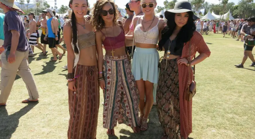 Cztery dziewczyny w letnich strojach pozują na tle festiwalu. W tle widać diabelski młyn. Ile trwa Coachella? Zwykle dwa weekendy.