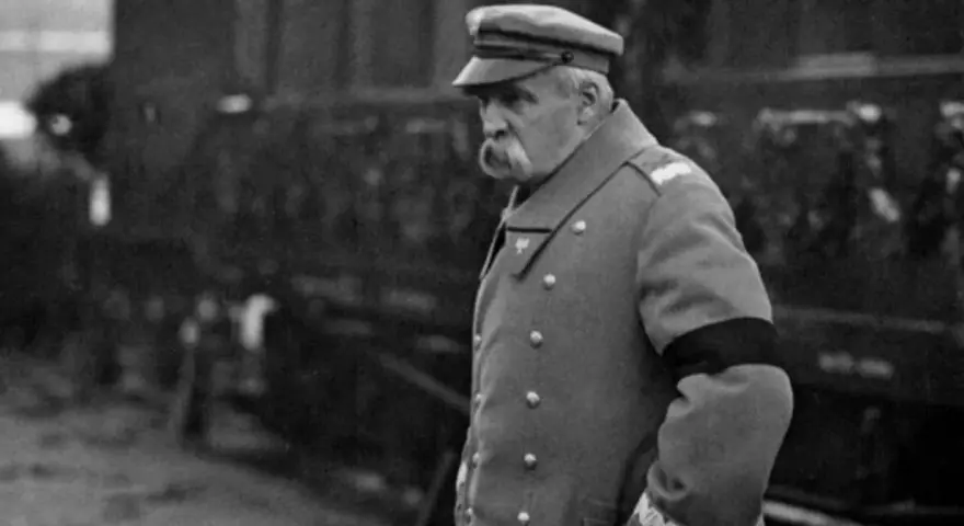 Marszałek Józef Piłsudski w mundurze, z czarną opaską na ramieniu, symbolizującą żałobę. W tle widać tłum ludzi, być może podczas uroczystości pogrzebowych, gdy Józef Piłsudski jak zmarł.