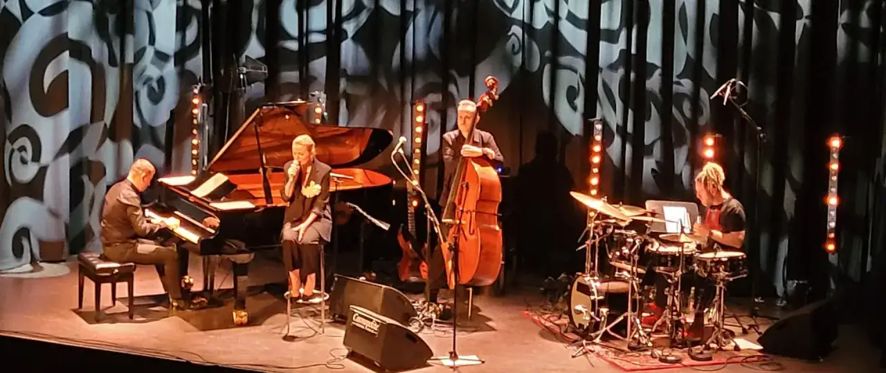 Anna Maria Jopek śpiewa na scenie z zespołem: pianista, kontrabasista i perkusista.